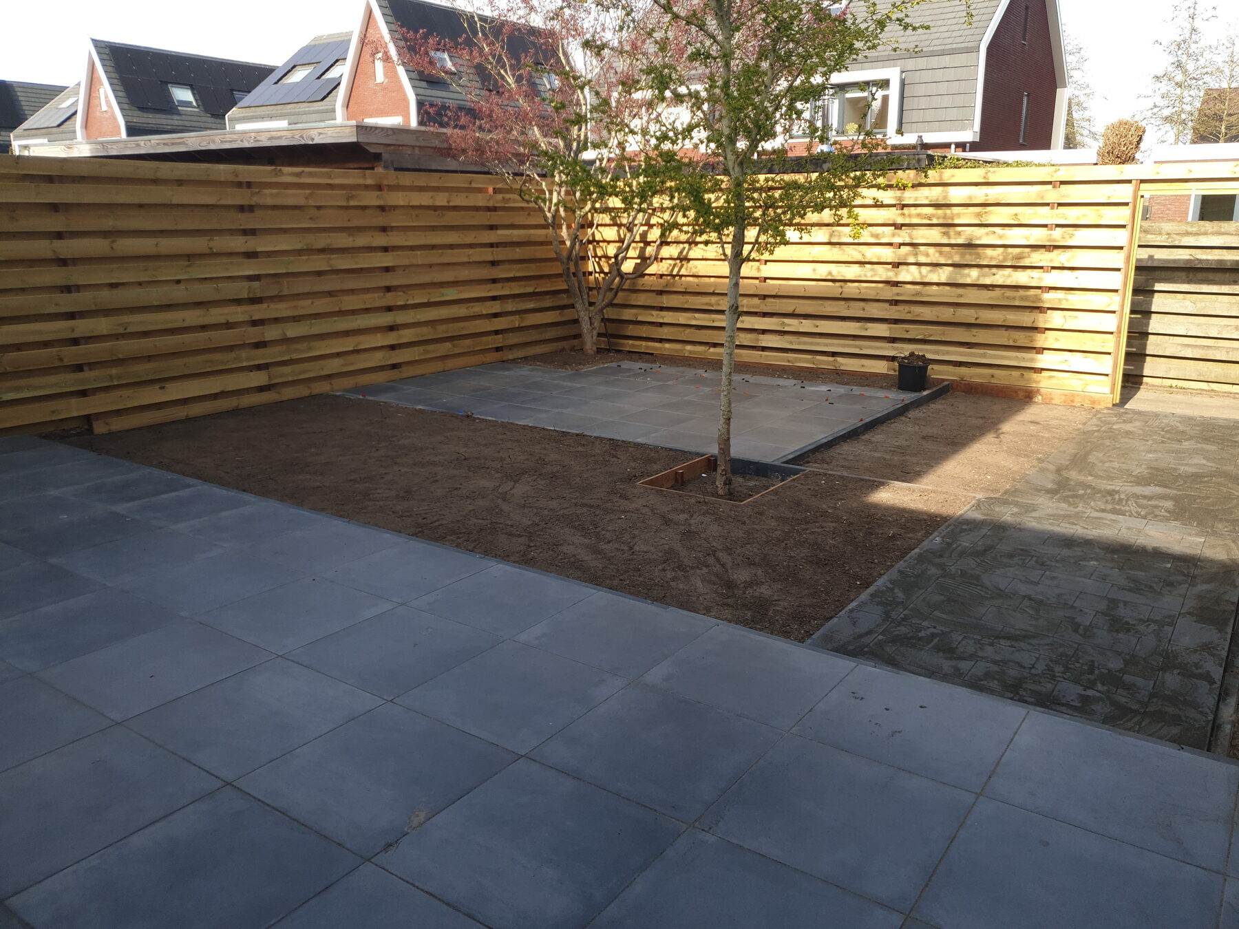 Door Iddo's Groenservice aangelegde tuin met bestrating en boom